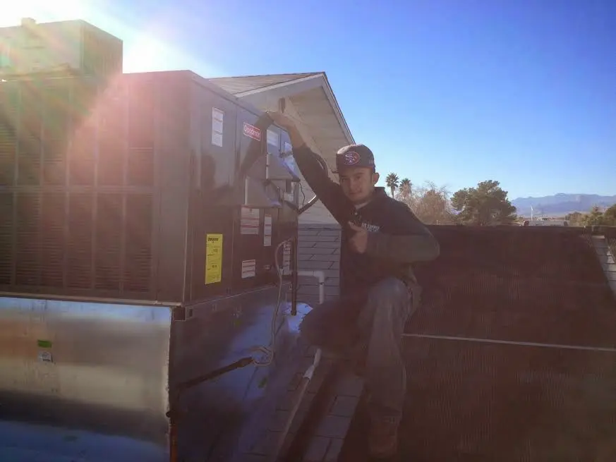 HVAC technician performing HVAC Inspection on a rooftop unit in Long View